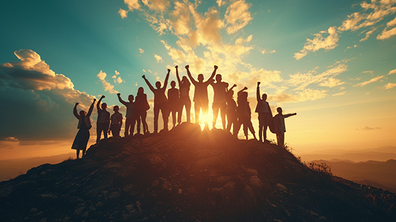 Silhouetted group celebrating on a hilltop at sunrise, arms raised in unity and triumph against a glowing sky.